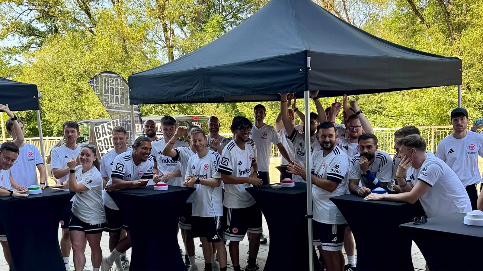 Teams stehen beim gemeinsamen Quiz im Halbfinale der Gameshow an den Quiztischen