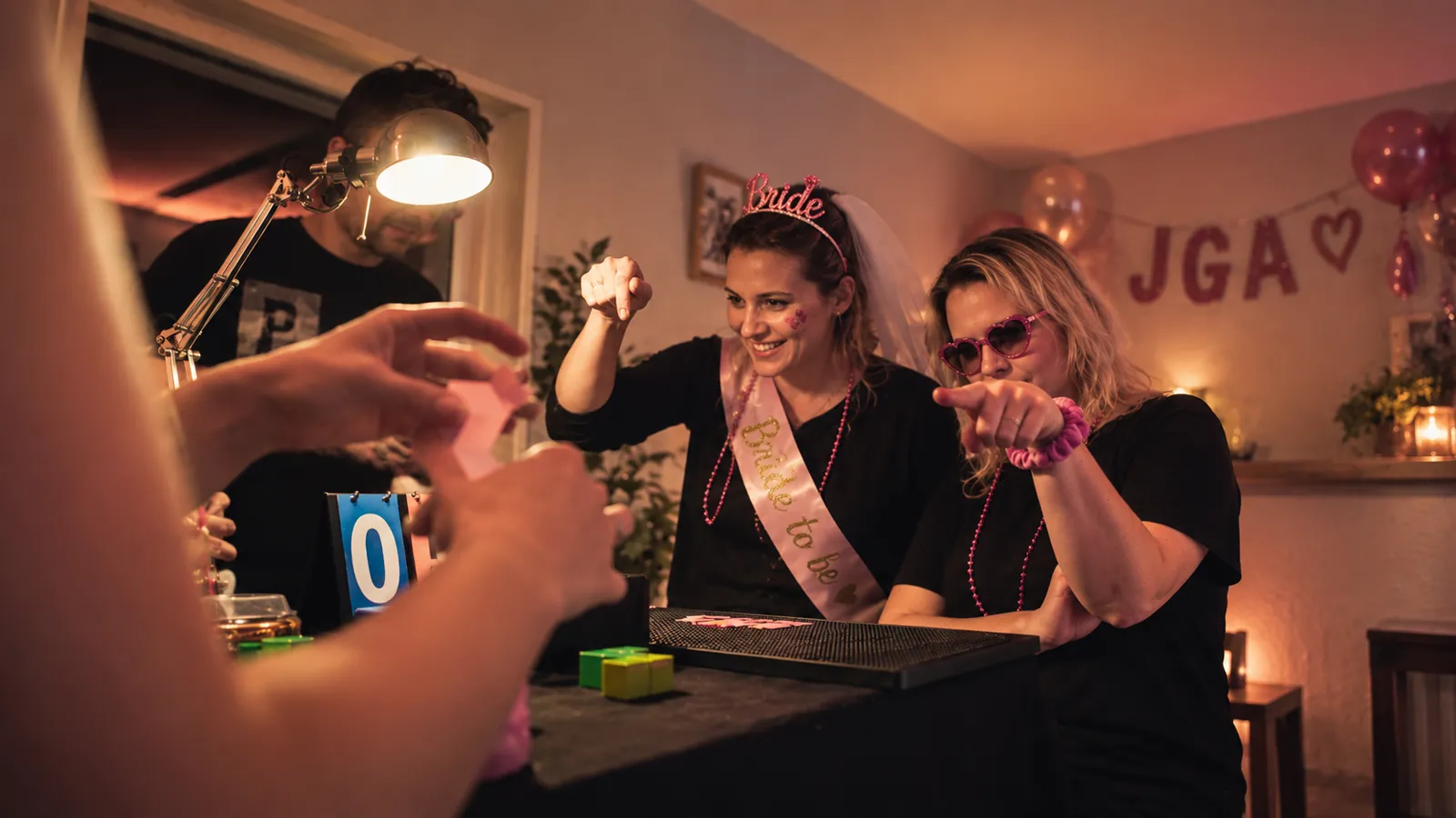 Braut mit Bride-to-be-Schärpe spielt mit ihren Freundinnen bei der JGA-Gameshow