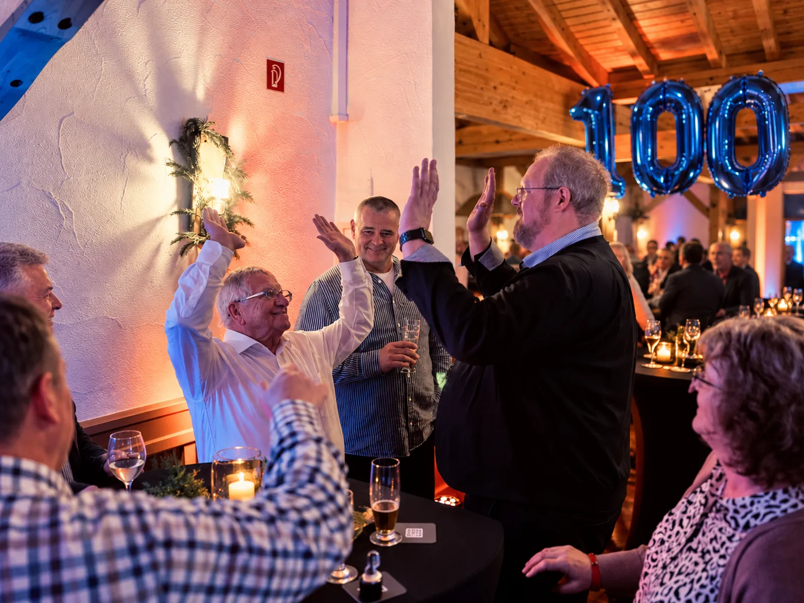 High-Five unter Kollegen beim 100-jährigen Firmenjubiläum