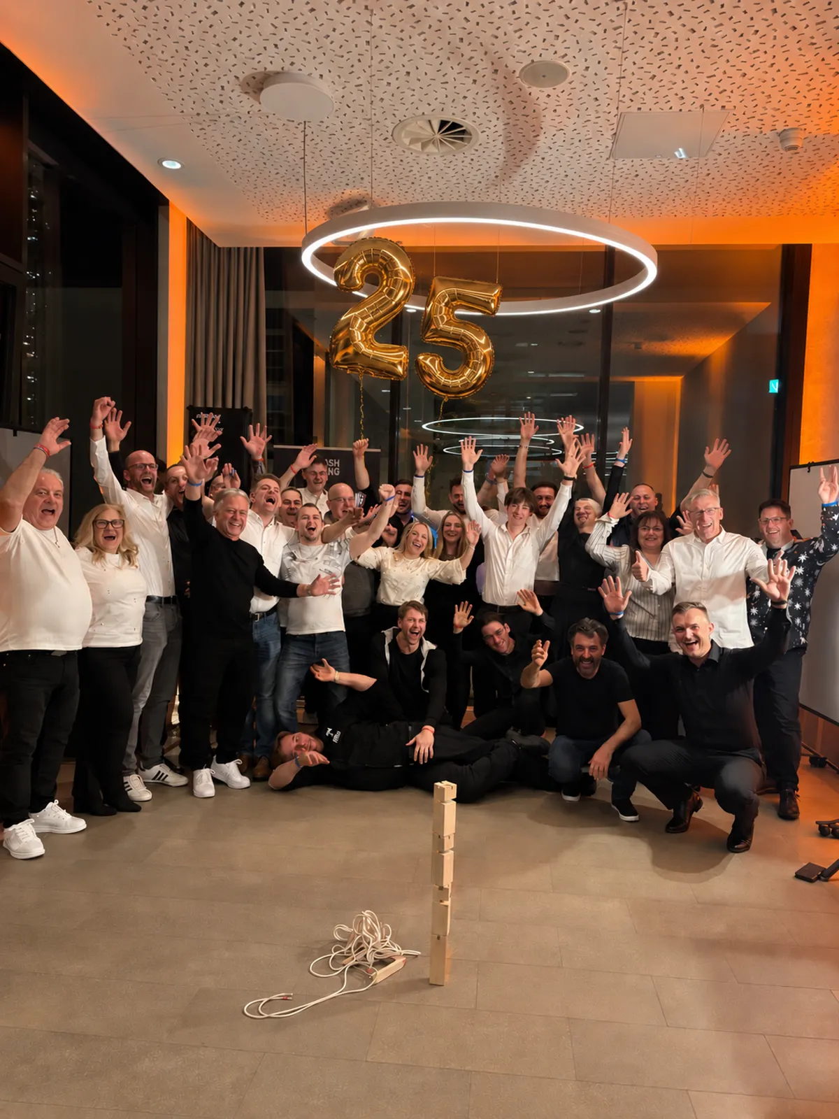 Jubelndes Team mit goldenen 25-Jahre-Ballons bei der Firmen-Jubiläumsfeier