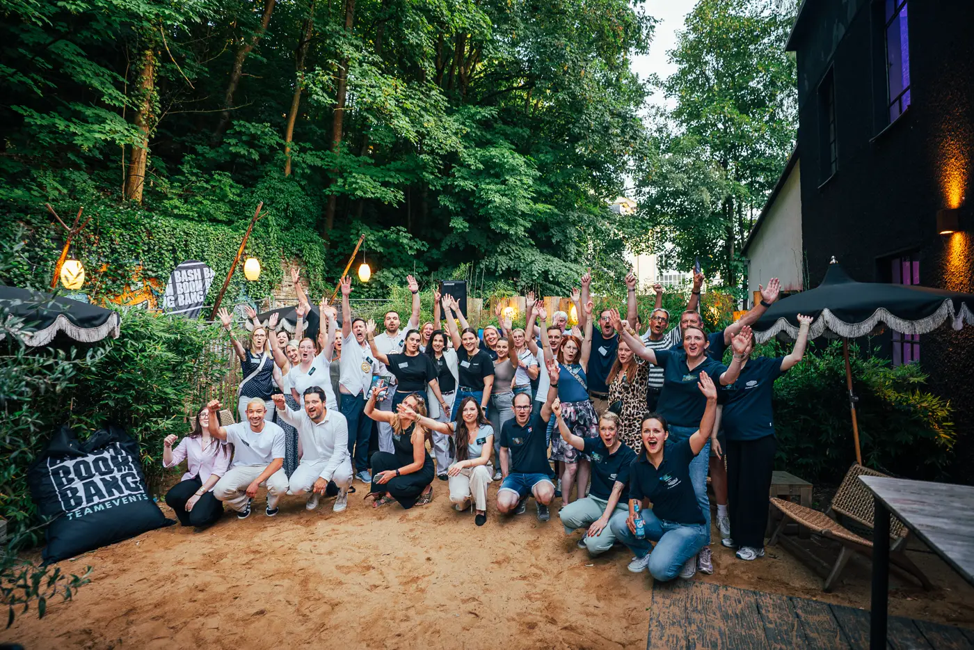 Jubelndes Team beim Gruppenfoto auf dem Firmen-Sommerfest im Freien
