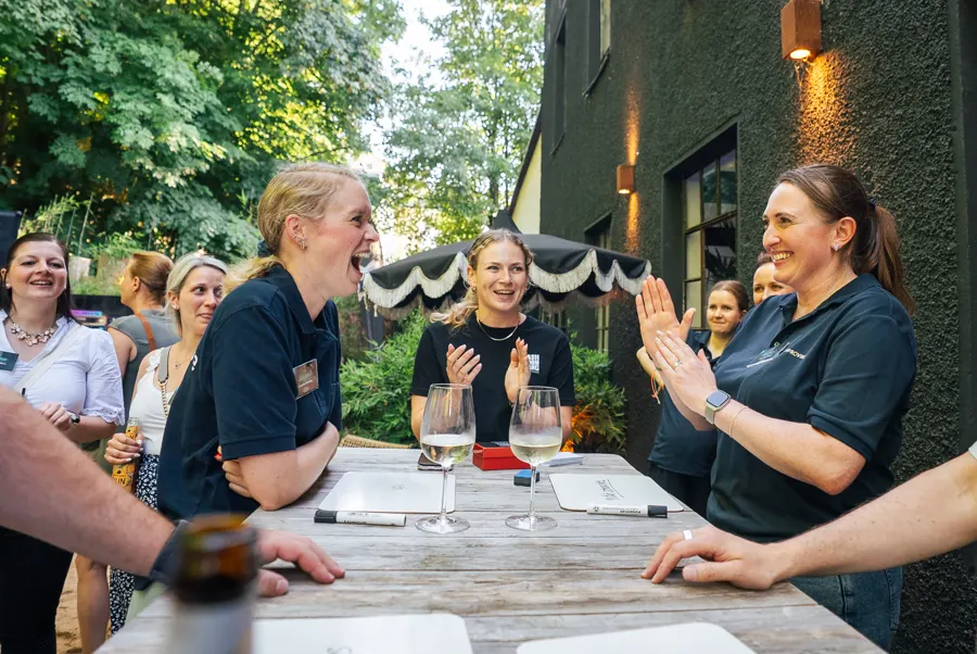 Kolleginnen applaudieren beim Quiz im Freien